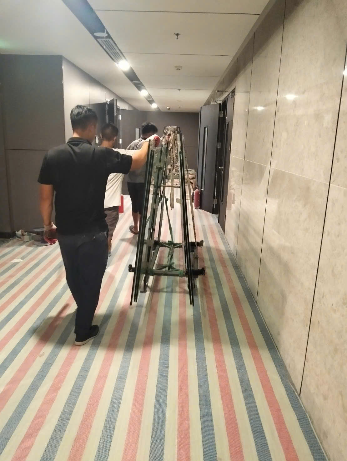 Đội ngũ đưa giá kính qua hành lang bên trong công trình